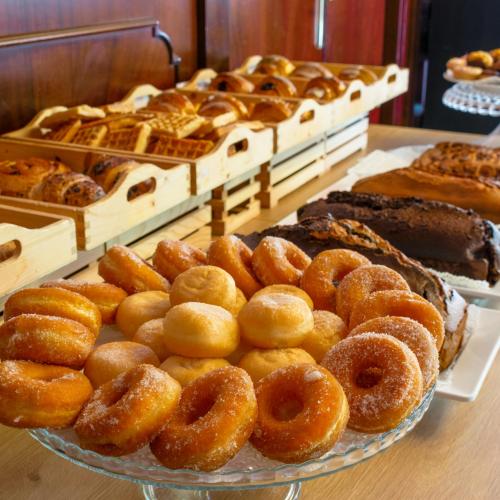 Vielfalt an Gebäck und Donuts auf einem Buffet-Tisch.